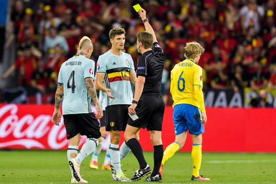 Belgiens Thomas Meunier får gult kort av domare Felix