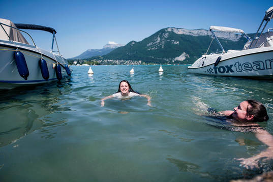 Två tjejer badar i Lake Annecy  där Island har sitt