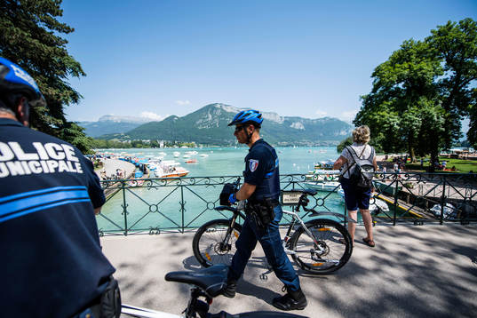 Cyklande poliser vid Lake Annecy där Island har sitt