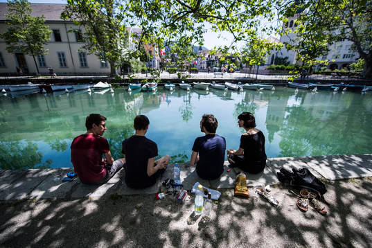 Ungdomar från Annecy  har picknick vid ån där Island har
