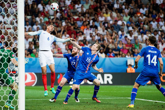 Englands Chris Smalling mot Islands Aron Gunnarsson och