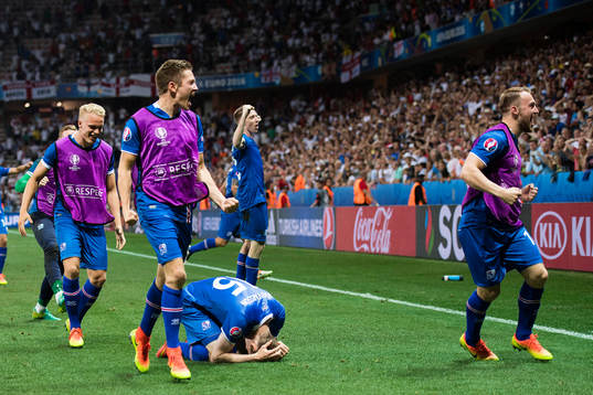 Islands spelare med Hjörtur Hermannsson (tv)) jublar