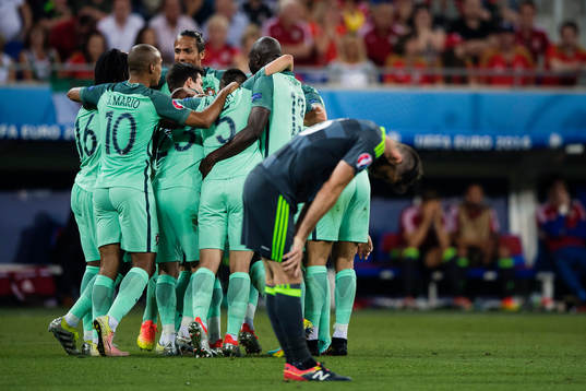 Wales Joe Ledley deppar medan Portugals spelare jublar