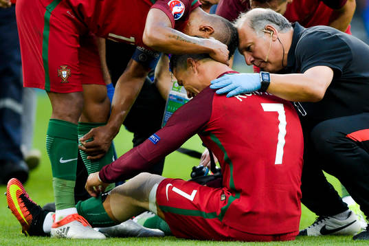 Portugals Cristiano Ronaldo blir tröstad av lagkamrater