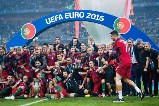 Portugals spelare med pokalen jublar mot Cristiano Ronaldo