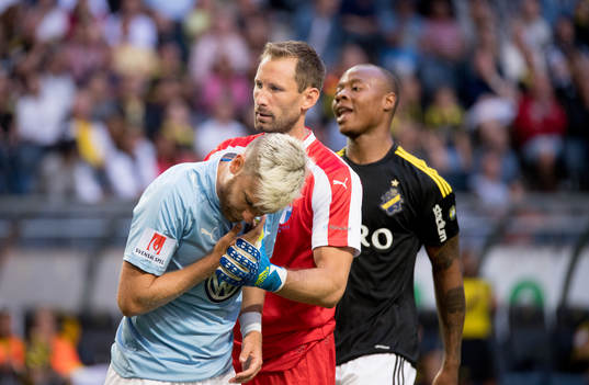Malmö FFs Rasmus Bengtsson tas om hand av Johan Wiland