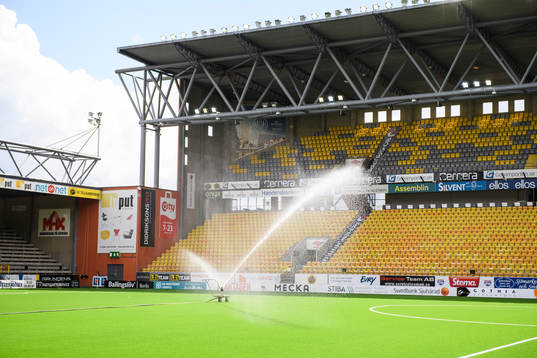 Vattning av konstgräset innan fotbollsmatchen i
