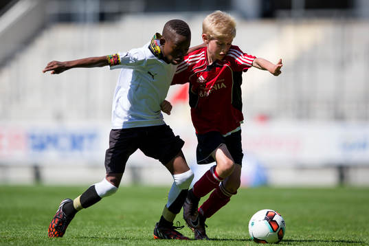 En spelare i Lizzy Football Club i kamp om bollen med en