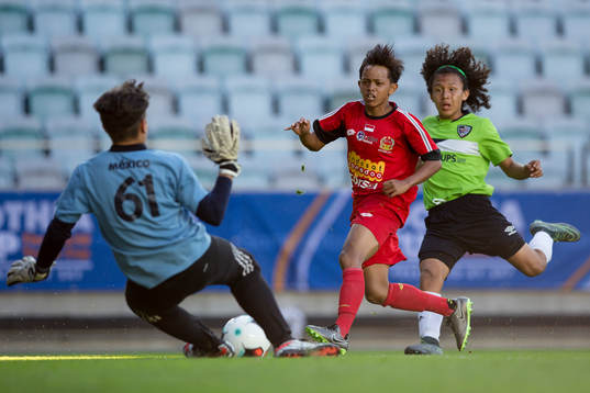 En Topskor Indonesia spelare skjuter ett skott i Gothia Cup