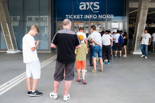 Folk i kö till att köpa biljetter innan fotbollsmatchen i