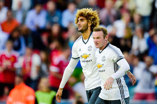 Manchester Uniteds Wayne Rooney och Marouane Fellaini jublar