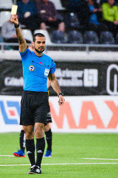 Domare Mohammed Al-Hakim visar det gula kortet