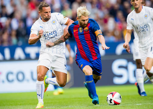 Barcelonas Leo Messi i kamp om bollen med Leicester Citys