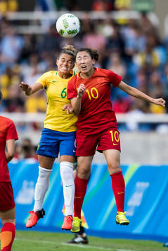 Brasiliens Tamires och Kinas Li Yang i fotbollsmatchen