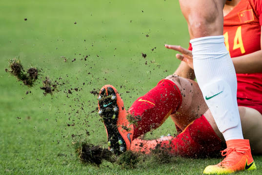 Tackling i fotbollsmatchen mellan Brasilien och Kina