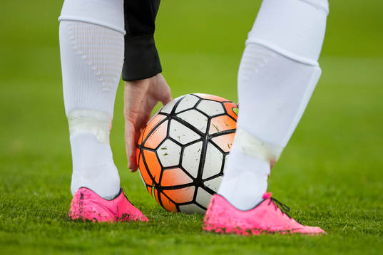 En spelare plockar upp en boll