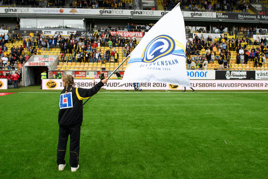 Ung tjej med Allsvenskan fana innan fotbollsmatchen i