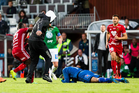 Person tar sig in på planen och jagar ifatt och slår ner