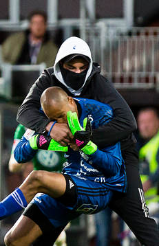 Person jagar och slår ner Östersunds Aly Keita