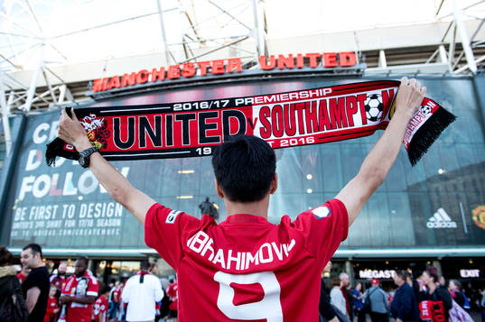 En supporter i Zlatan Ibrahimovic matchtröja håller upp