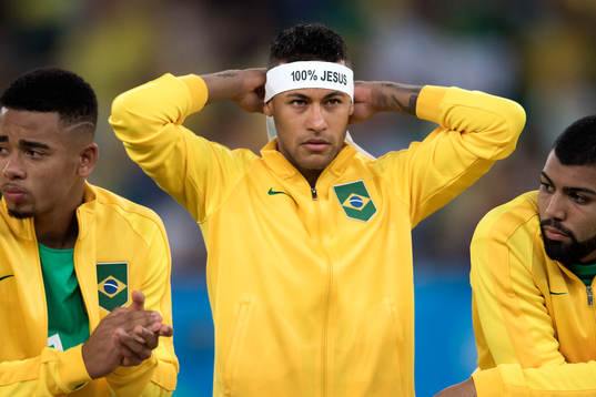 Brasiliens Neymar tar på sin en bindel med texten "100%