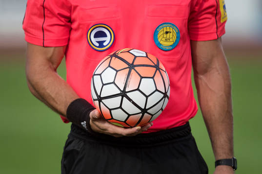 Domare Kasper Sjöberg håller matchbollen i sin hand
