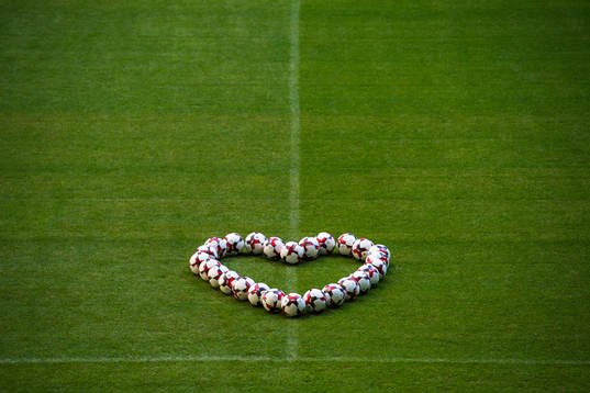 Fotbollar placerade i form av ett hjärta