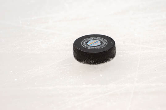 En puck med emblemet för World Cup ligger på isen