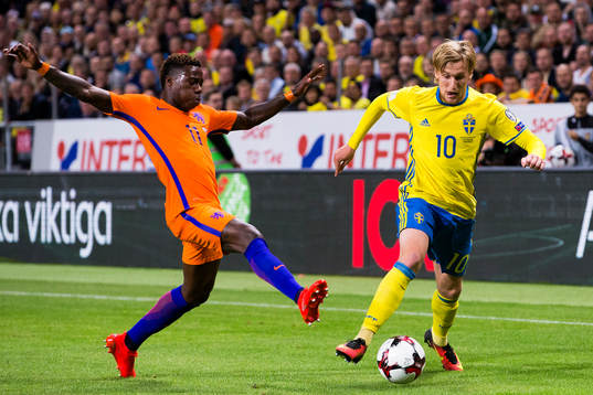 Hollands Quincy Promes i kamp om bollen med Sveriges Emil