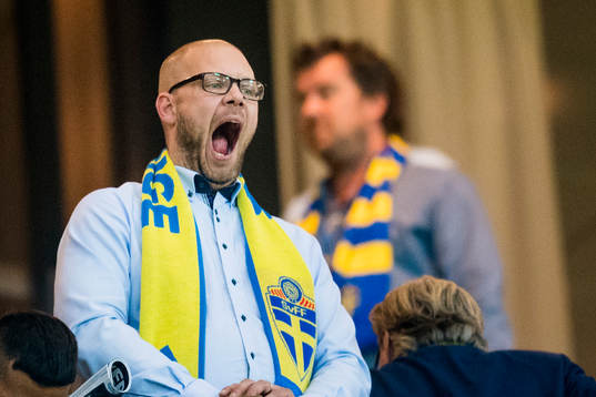 En svensk supporter med halsduk gäspar