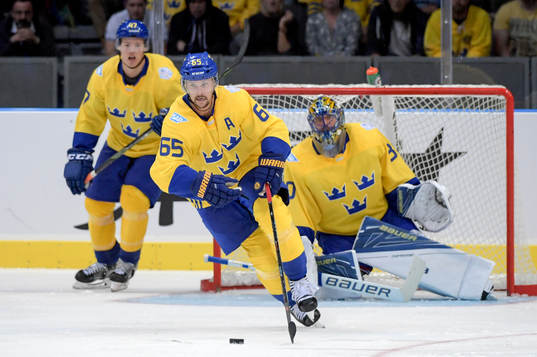 Sveriges Erik Karlsson framför Hampus Lindholm och