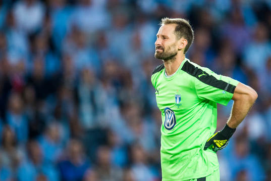 Malmö FFs målvakt Johan Wiland tar sig för ryggen och