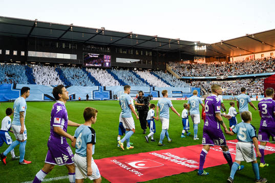 Spelarna går ut på planen före fotbollsmatchen i