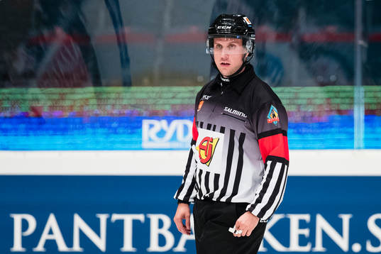 Domare Patrik Bjälkander iförd
