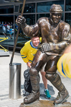 En svensk supporter bli fotograferad vid en staty av Mats