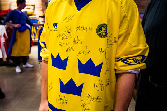 En person bär en svensk matchtröja med autografer