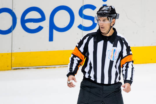 Domare Wes McCauley med en specialhjälm innehållandes