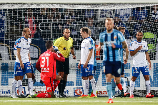 Domare Kaspar Sjöberg diskuterar med spelarna om ett mål