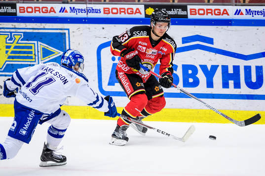 Luleås Julius Junttila med pucken utmanas av Leksands