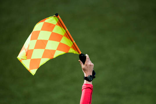 Linjedomaren viftar för offside