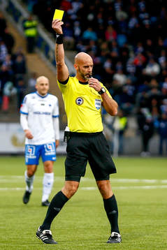 Domare Stefan Johannesson delar ut ett gult kort