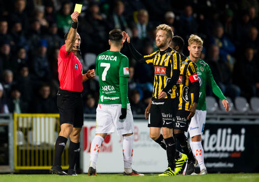 Domaren Kaspar Sjöberg delar ut ett gult kort till