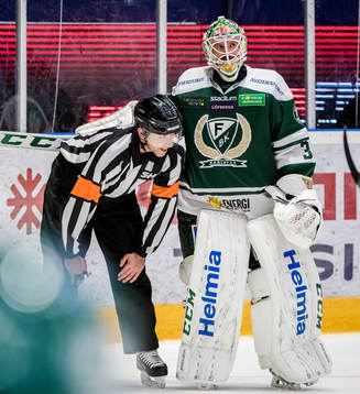 Domare Linus Öhlund pratar med Färjestads målvakt Lars