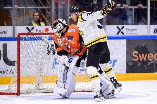 Brynäs Nick Johnson tacklar Karlskronas målvakt Johan