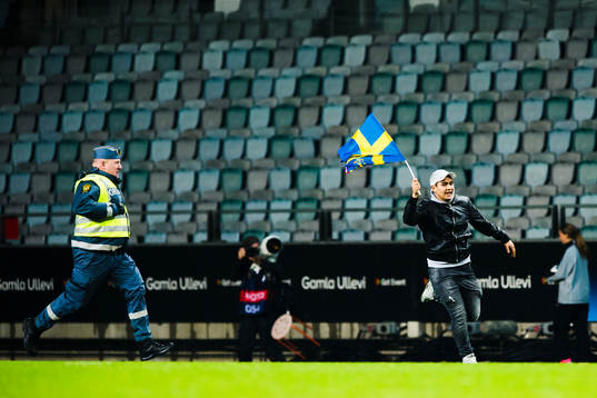 En ordningsvakt jagar e person som sprang in på plan
