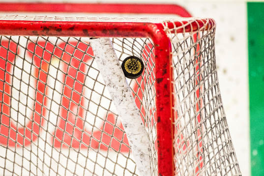 En puck som fastnat i målramen