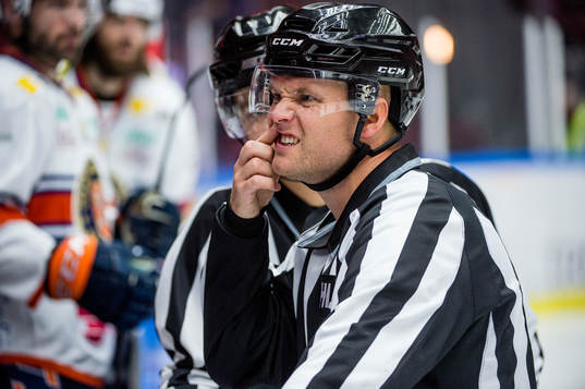 Linjedomare Ludvig Lundgren får en puck på munnen