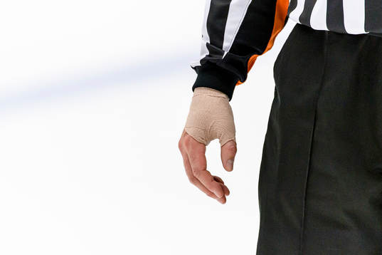 Domare Mikael Sjöqvist  med bandage runt handen