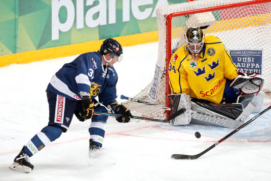Finland¥s Mika Pyörälä and Sweden¥s goalie Joel