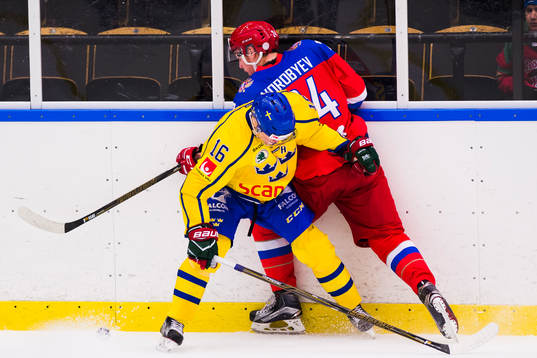 Sveriges Carl Grundström i kamp om pucken med Rysslands